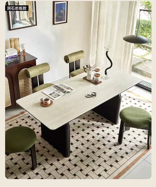 Modern dining room with a long table and chairs on a patterned floor.