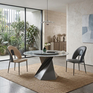 Modern dining room with a round marble table and chairs.