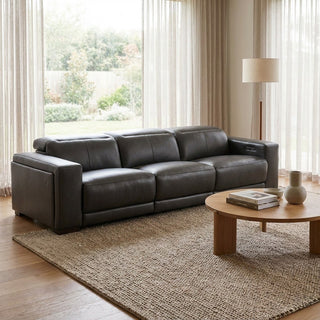 Modern living room with a dark leather sofa and wooden coffee table.