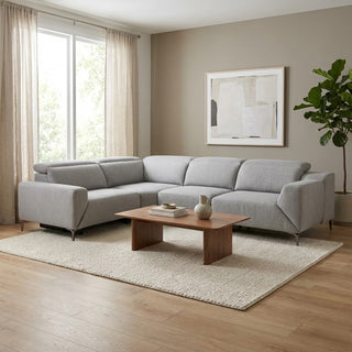 Modern living room with a grey sectional sofa, wooden coffee table, and abstract art on the wall.