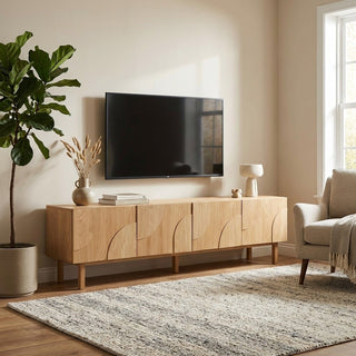 Modern living room with wooden TV stand, television, and decorative items.