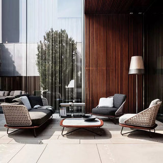 Modern outdoor seating area with chairs, table, and lamp in a stylish setting.