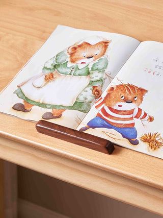 Open book with teddy bear illustrations on a wooden surface