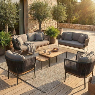 Outdoor patio furniture set with cushions on a wooden deck.