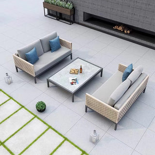 Outdoor patio furniture set with two sofas and a coffee table on a tiled patio.