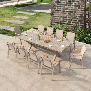 Outdoor patio set with a wooden table and chairs on a stone patio.