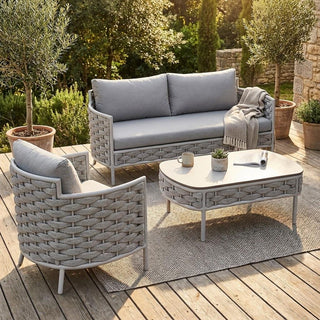 Outdoor patio set with gray cushions and furniture on a wooden deck.