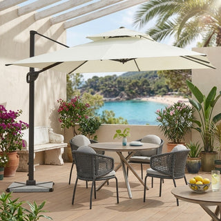 Outdoor patio set with table, chairs, and large umbrella overlooking a scenic view.