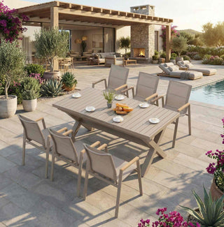 Outdoor patio setting with a wooden dining table and chairs near a pool.