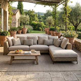 Outdoor patio with a sectional sofa, coffee table, and potted plants.