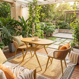 Outdoor patio with balcony table set, surrounded by plants and a stone pathway.