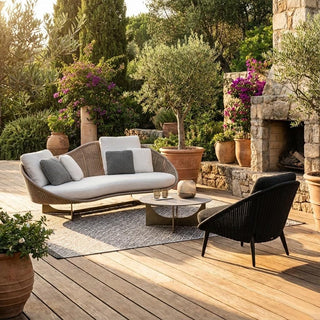 Outdoor patio with wicker sofa, armchair, and coffee table on a wooden deck.