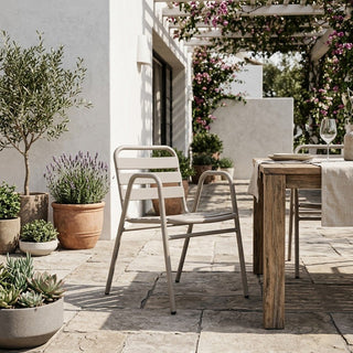 Outdoor patio with wooden table, chairs, and potted plants on a sunny day.