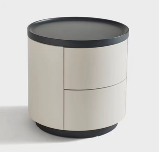 Round bedside table with a beige body and black trim on a white background