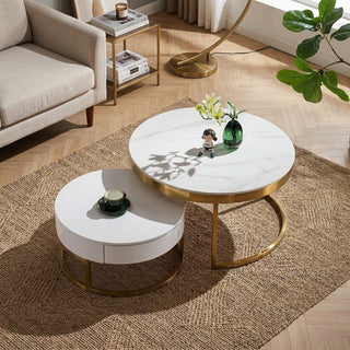 Round white coffee table with gold legs in a living room setting.