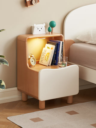 Small wooden side table with a lamp, books, and decorative items in a room setting.