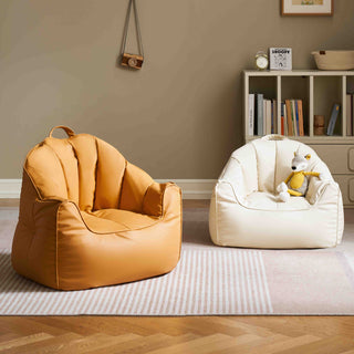 Two childrens bean bags, one yellow and one white with a plush toy, in a room with a bookshelf and decor.
