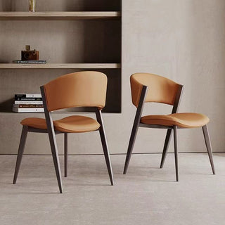 Two modern dining chairs with brown seats and black frames in a minimalistic room.