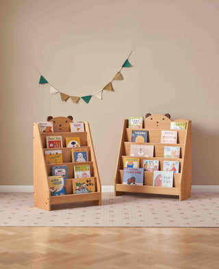 Two wooden children's bookshelves with books against a beige wall.