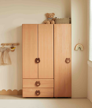 Wooden Childrens wardrobe with teddy bear on top in a child's room