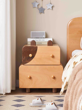 Wooden childrens nightstand with star decorations on a wall in a bedroom setting.
