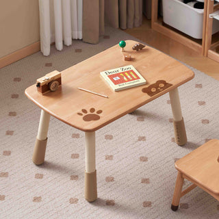 Wooden childrens play table with paw print design on a carpeted floor.