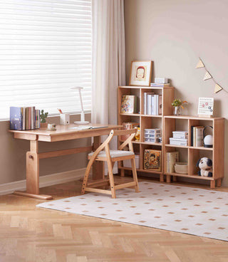 Wooden desk and chair in a room with a bookshelf and decor items.