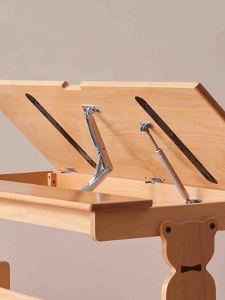 Wooden drafting table with adjustable height and angle on a beige background