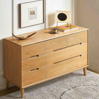 Wooden dresser with four drawers in a room setting.