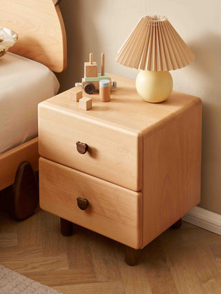 Wooden kids nightstand with a lamp and toys on a wooden floor.