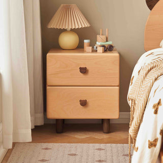 Wooden kids nightstand with two drawers, lamp, and toys in a bedroom setting.