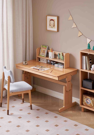 Wooden kids study desk with chair in a room with a beige wall and decorative elements.