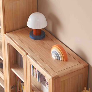 Wooden shelf with a lamp and rainbow-shaped object against a beige wall