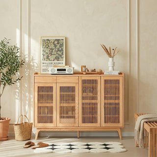 Wooden shoe cabinet with decorative items in a room with a plant and rug.