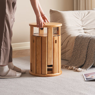 Wooden side table being pushed by a person in a living room setting.