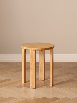 Wooden side table on a wooden floor with a beige wall background
