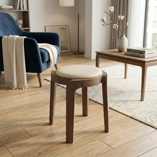 Wooden stool with a cushioned seat in a living room setting