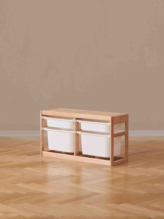 Wooden storage unit with white bins on a wooden floor against a beige wall