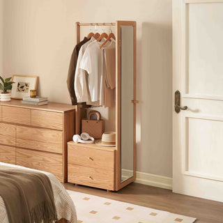 Wooden wardrobe with mirror and clothing in a bedroom setting