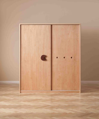 Wooden wardrobe with sliding doors on a beige wall and wooden floor.