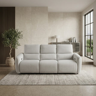 beige 3 seater recliner sofa in a modern living room with a plant and window.