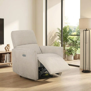 beige recliner chair in a living room setting with plants and a lamp.