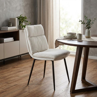 beige upholstered chair in a modern living room with a wooden table and decor.