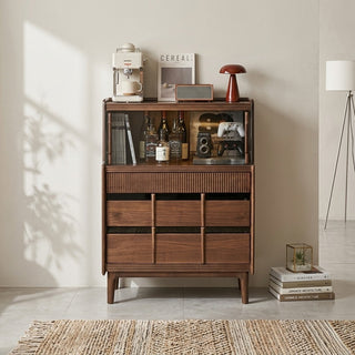 black walnut storage cabinet with decorative items in a room with sunlight casting shadows.