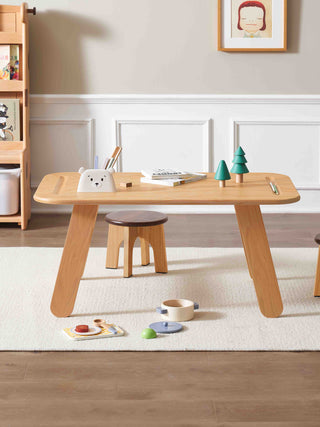 childrens activity table, stools, and toys on a light-colored rug.
