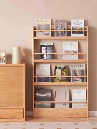 childrens wooden bookshelf with books against a beige wall