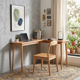 corner study table with chair in a home office setting with plants and decor.