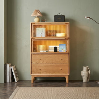 display cabinet with books and decor items against a green wall