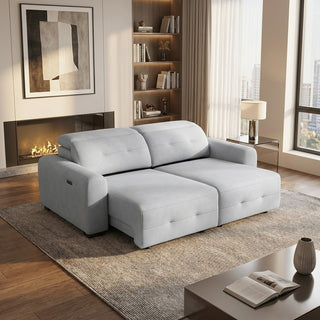 grey slider sofa in a living room with a fireplace and bookshelf.