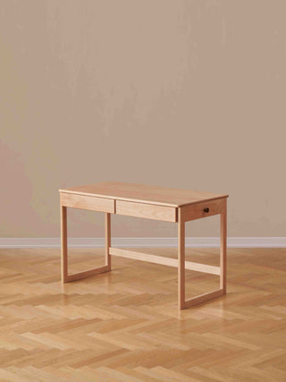 kids Wooden desk with two drawers on a wooden floor against a beige wall